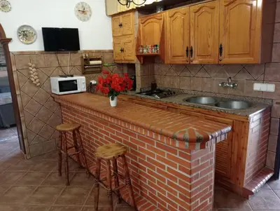 a patio with a roof with a table and chairs at RURAL EL SANTISCAL in Arcos de la Frontera