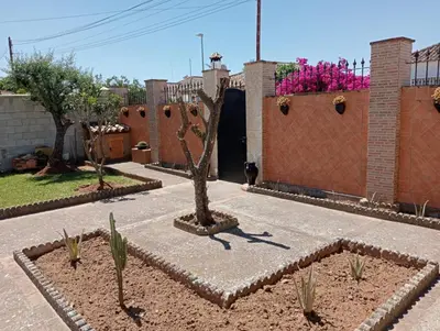a brick fence with a black gate and a building at RURAL EL SANTISCAL in Arcos de la Frontera