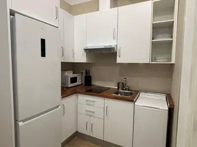 a kitchen with white cabinets and a refrigerator at Estudio Las Navas in Cádiz