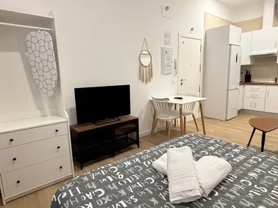 a bedroom with a bed and a tv and a table at Estudio Las Navas in Cádiz