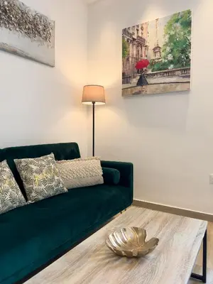 a living room with a green couch and a table at El Rincón de Fabio Little Apartments in Cádiz