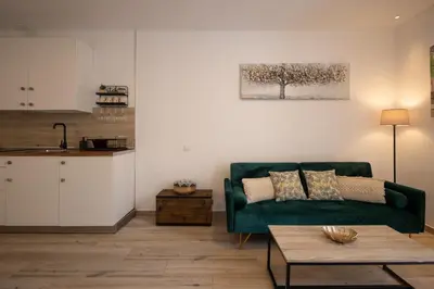 a living room with a green couch and a table at El Rincón de Fabio Little Apartments in Cádiz