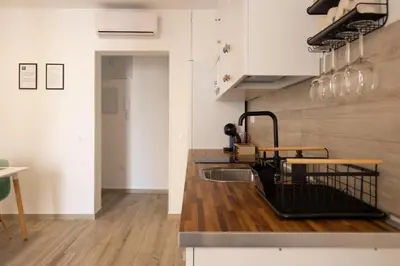 a kitchen with white cabinets and a sink at El Rincón de Fabio Little Apartments in Cádiz