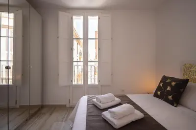 a bedroom with a bed with two white pillows on it at El Rincón de Fabio Little Apartments in Cádiz