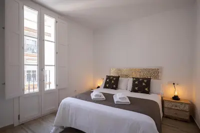 a bedroom with a large bed with two towels on it at El Rincón de Fabio Little Apartments in Cádiz