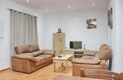 a living room with two couches and a tv at Villa Ana in Conil de la Frontera
