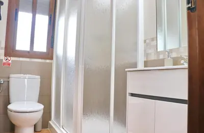 a bathroom with a shower with a toilet and a sink at Villa Ana in Conil de la Frontera