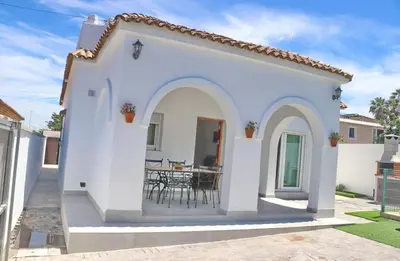 a white house with a patio with a table at Villa Alonso in Conil de la Frontera
