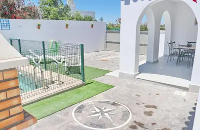 a patio with a gate and grass at Villa Alonso in Conil de la Frontera