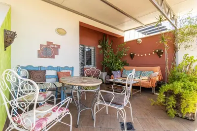 a patio with a table and chairs and a couch at Mirador del Sur Penthouse & SunSet - Free Parking in Jerez de la Frontera