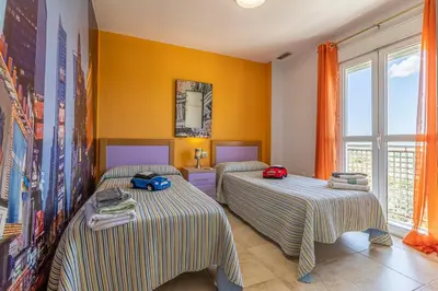 two beds in a room with yellow walls at Mirador del Sur Penthouse & SunSet - Free Parking in Jerez de la Frontera