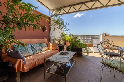 a living room with a couch on a patio at Mirador del Sur Penthouse & SunSet - Free Parking in Jerez de la Frontera