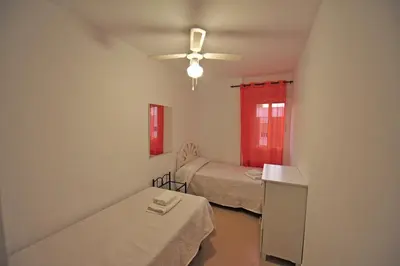 a room with two beds and a ceiling fan at Laguna 3 dormitorios Acogedor in Cádiz