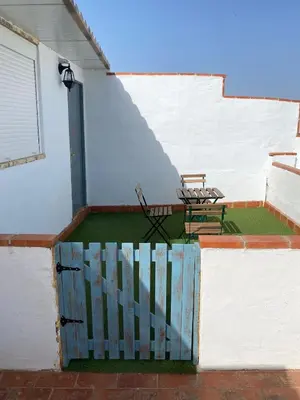 a patio with two chairs and a table on a building at El Jardín de Lucas in Arcos de la Frontera