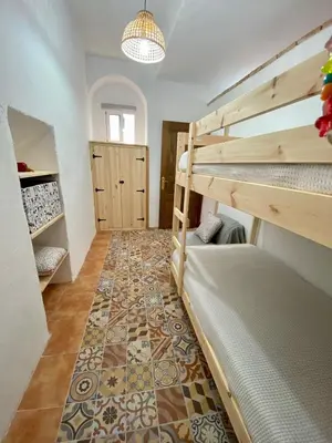 a room with two bunk beds and a rug at El Jardín de Lucas in Arcos de la Frontera