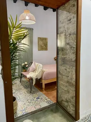 a living room with a chair and a mirror at El Jardín de Lucas in Arcos de la Frontera