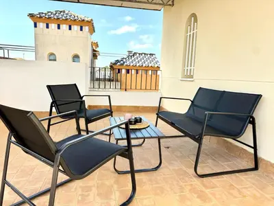 two chairs and a table on a patio at Mirador de Doñana Nº 14, Apartamentos Living Sur in Sanlúcar de Barrameda