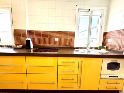 a kitchen with yellow cabinets and a sink at Mirador de Doñana Nº 14, Apartamentos Living Sur in Sanlúcar de Barrameda