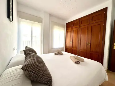 a bedroom with a bed with two towels on it at Mirador de Doñana Nº 14, Apartamentos Living Sur in Sanlúcar de Barrameda