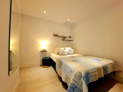 a bedroom with a bed and a light on the wall at Apartamento Barrosa Pista in Chiclana de la Frontera