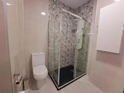 a bathroom with a toilet and a glass shower at Apartamento Barrosa Pista in Chiclana de la Frontera