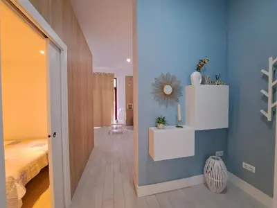 a room with a hallway with a bed and a mirror at Apartamento Barrosa Pista in Chiclana de la Frontera