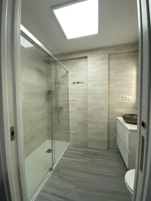 a bathroom with a shower with a glass door at Molineros Victoria Beach in Cádiz