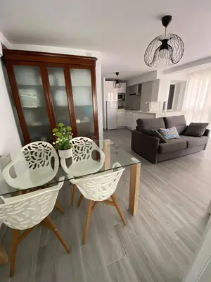 a living room with a glass table and two chairs at Molineros Victoria Beach in Cádiz