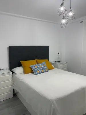 a bedroom with a large bed with yellow pillows at Molineros Victoria Beach in Cádiz