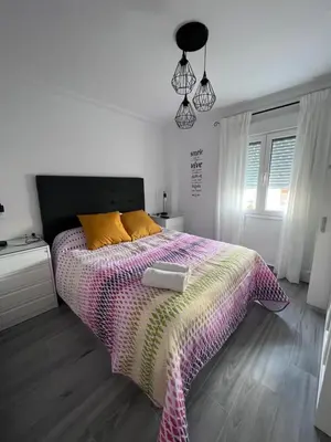 a bedroom with a large bed with a colorful comforter at Molineros Victoria Beach in Cádiz