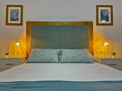 a bedroom with a king sized bed with two lamps at Apartamento Alborada - Ole Solutions in Sanlúcar de Barrameda
