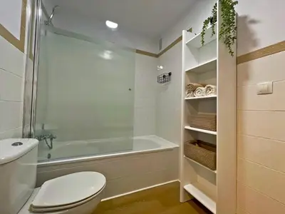 a bathroom with a shower and a toilet and a tub at Apartamento Alborada - Ole Solutions in Sanlúcar de Barrameda