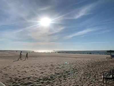 a couple of people walking on the beach at Apartamento Alborada - Ole Solutions in Sanlúcar de Barrameda