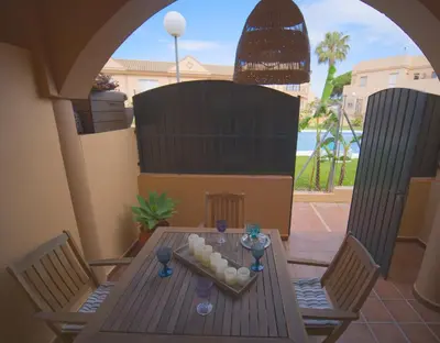a wooden table with two chairs and balls on it at Apartamento Residencial Al Andalus 117, La Barrosa, Chiclana, Incluye parking a unos metros del mar in Chiclana de la Frontera