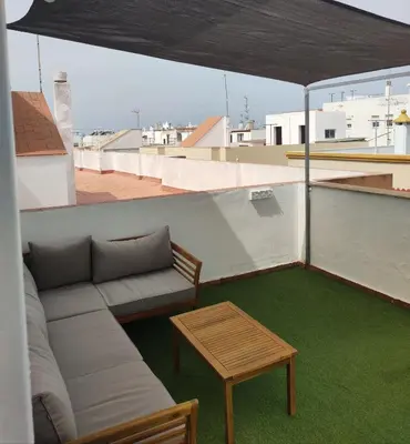 a couch and a table on a roof at La Terraza de Natipao in Rota