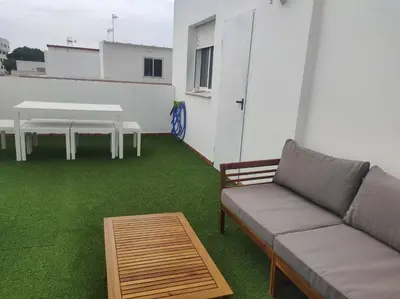 a living room with a couch and a table and grass at La Terraza de Natipao in Rota