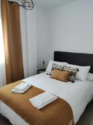a bed with two white towels on top of it at La Terraza de Natipao in Rota