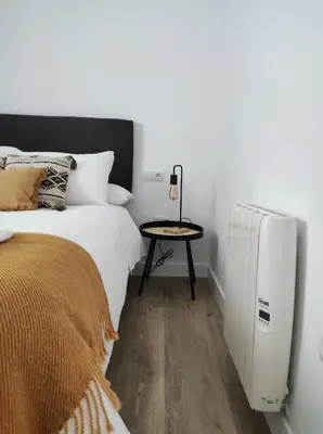a bedroom with a white radiator next to a bed at La Terraza de Natipao in Rota