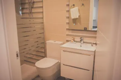 a small bathroom with a toilet and a sink at Apartamentos Puerta Sevilla in Jerez de la Frontera