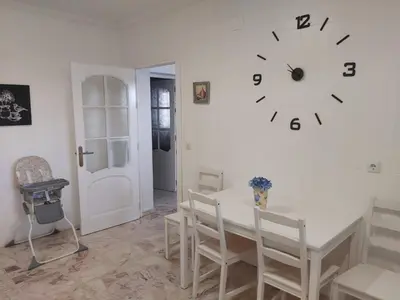 a dining room with a table and a clock on the wall at Casa Selene in El Puerto de Santa María
