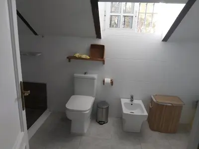 a white bathroom with a toilet and a sink at Casa Selene in El Puerto de Santa María