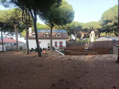 a white house with a fence in front of a yard at Casa Selene in El Puerto de Santa María