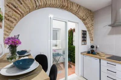 a kitchen with an archway and a table with bowls on it at ENTREARCOS in Cádiz