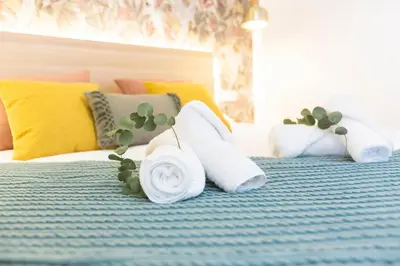 a bed with a pillow with a flower on it at ENTREARCOS in Cádiz