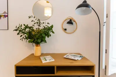a table with a lamp and a vase with a plant at ENTREARCOS in Cádiz