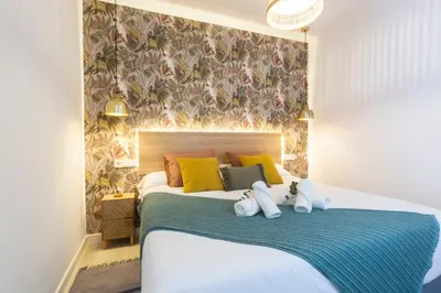 a bedroom with a bed with yellow and green pillows at ENTREARCOS in Cádiz