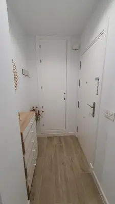a room with white walls and a wooden floor at APARTAMENTO A PIE DE PLAYA. in Cádiz