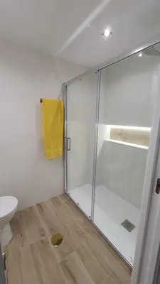 a bathroom with a shower with a yellow towel at APARTAMENTO A PIE DE PLAYA. in Cádiz