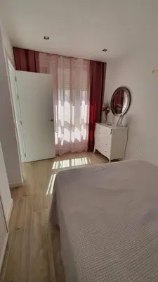 a bedroom with a bed and a dresser and a mirror at APARTAMENTO A PIE DE PLAYA. in Cádiz