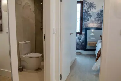 a bathroom with a toilet and a bedroom at CISNES PALACE in Sanlúcar de Barrameda